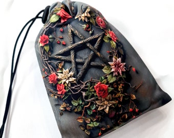 May include: A gray drawstring bag with a pentagram design surrounded by red and white flowers. The bag is made of a soft, silky fabric.
