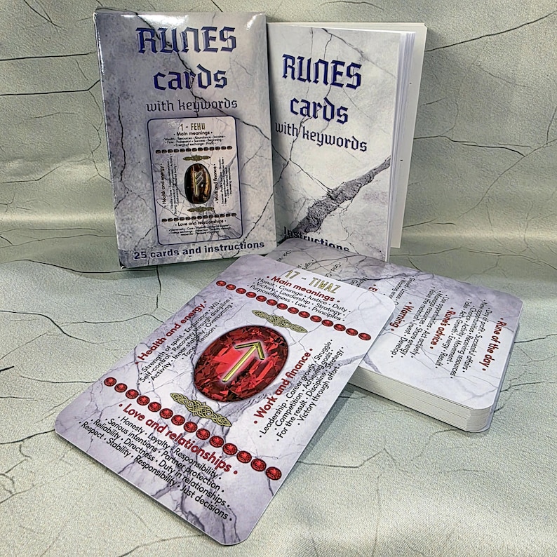May include: A set of rune cards with keywords, featuring a marble-textured design. The cards display symbols and text, including "Runes cards with keywords" and "25 cards and instructions." The cards are for divination and spiritual guidance.