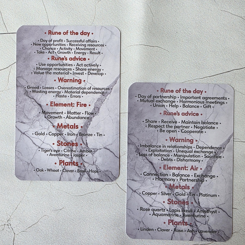 May include: Two tarot cards with a marble-like background. The cards feature lists of words under headings like "Rune of the day," "Rune's advice," and "Warning." The cards also list elements, metals, stones, and plants.
