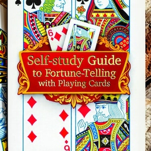 May include: A playing card with the text "Self-study Guide to Fortune-Telling with Playing Cards" on a red banner. The card features illustrations of playing card suits, including spades, clubs, and diamonds, and the text "Taromira Estelle".
