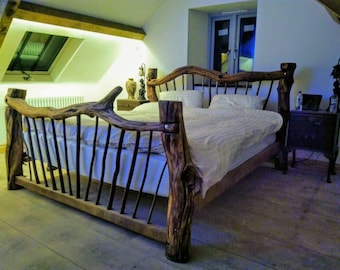 May include: A rustic wooden bed frame with a unique, natural branch design. The bed features a headboard and footboard crafted from thick, textured wood, with vertical black bars. The bed is made up with white linens and pillows.