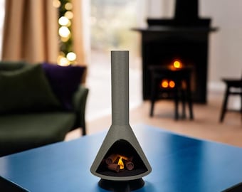 May include: A grey tabletop fireplace with a faux fire inside. The fireplace is on a blue table.