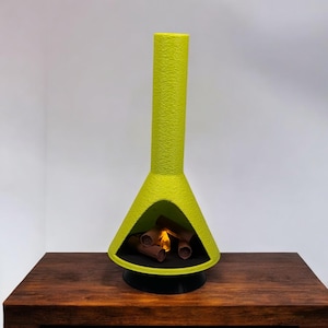 May include: A lime green ceramic fireplace with a faux fire inside. The fireplace is on a dark brown wooden surface.