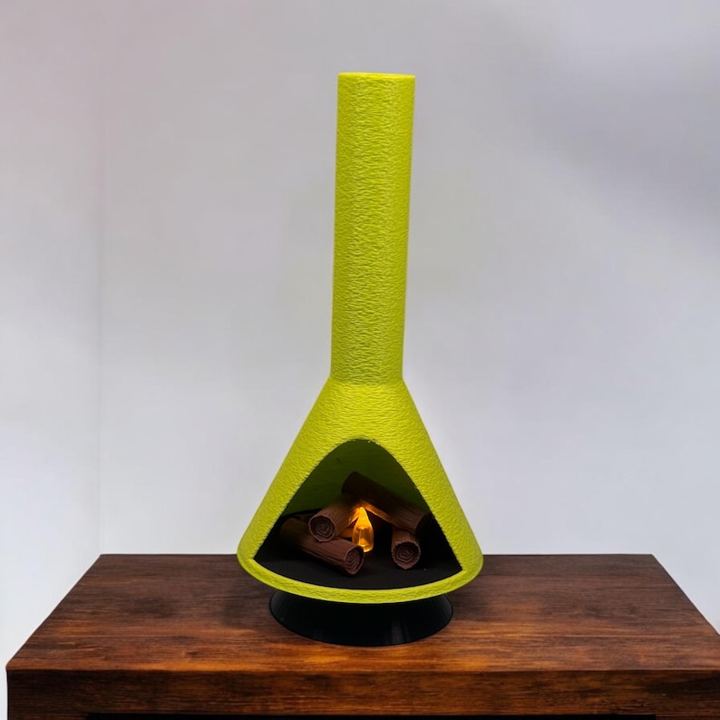 May include: A lime green ceramic fireplace with a faux fire inside. The fireplace is on a dark brown wooden surface.
