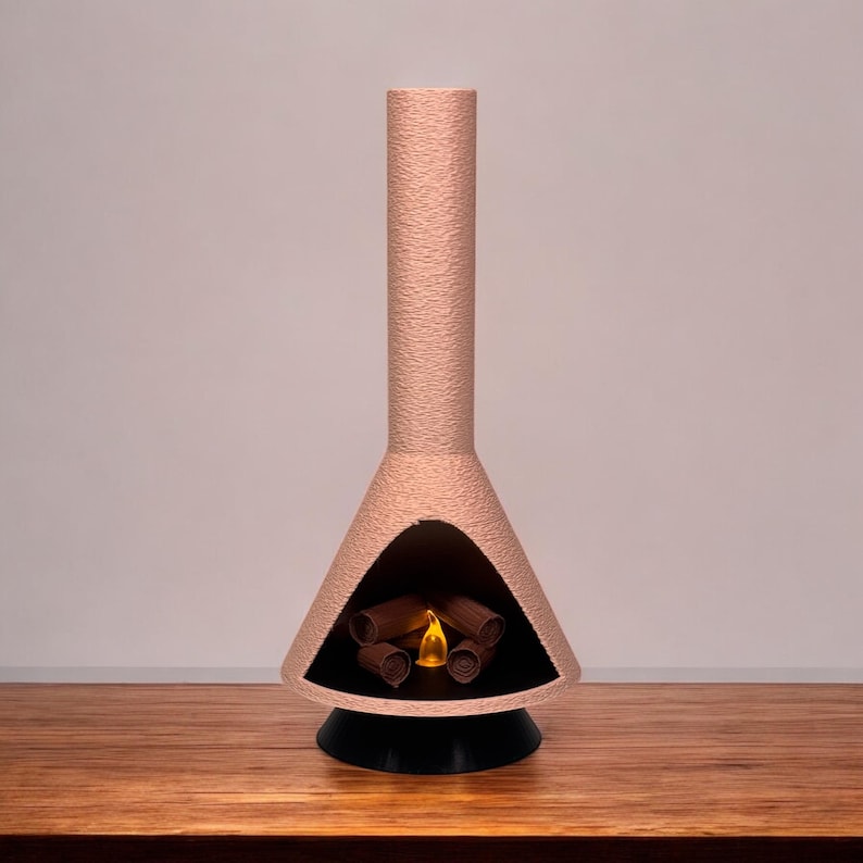 May include: A pink ceramic fireplace with a black base and a glowing orange flame inside. The fireplace is shaped like a cone with a tall chimney.