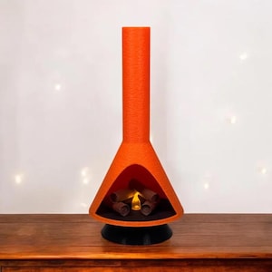 May include: A bright orange ceramic fireplace with a black base and a faux fire inside. The fireplace is shaped like a cone with a tall chimney.