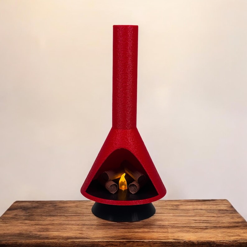 May include: A red, mid-century modern style fireplace with a black base and a glowing orange flame inside. The fireplace is made of a textured material and has a tall, cylindrical chimney.