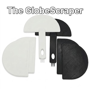 May include: A set of white and black plastic GlobeScraper tools. Each tool features a semi-circular scraping edge, a handle with an oval cutout, and a three-pronged tip at the base. The text The GlobeScraper is displayed at the top.