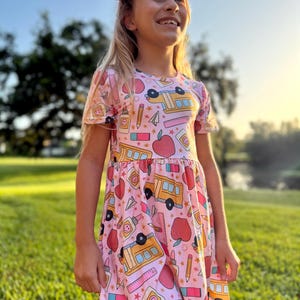 Vestido escolar rosa para niñas con lazo a juego: un atuendo preppy para la vuelta al cole