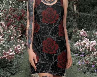 Puede incluir: Un vestido negro sin mangas con un patrón de rosas rojas y espinas. El vestido es corto y tiene una silueta ajustada. La modelo lleva el vestido y tiene tatuajes en los brazos y las piernas.