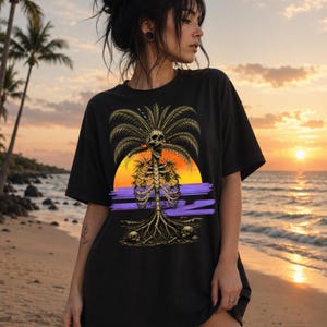 May include: A black t-shirt featuring a graphic print of a human ribcage and skull integrated into a palm tree. The design includes a sunset background with orange and yellow hues, purple horizontal brushstrokes, and two skulls at the base.
