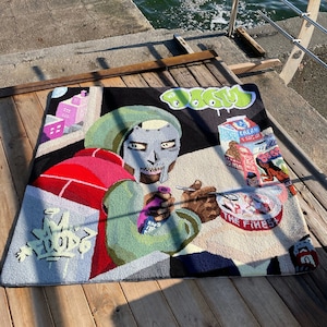 May include: A colorful rug with a cartoon image of a person wearing a mask and holding a bottle. The rug has a black background with graffiti-style writing and a bowl of cereal with the words "The Finest" on it.