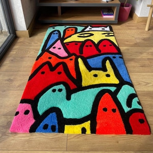 May include: A colorful rug with a cartoon-like design featuring a cat and other abstract shapes in shades of red, yellow, blue, green, pink, and black.