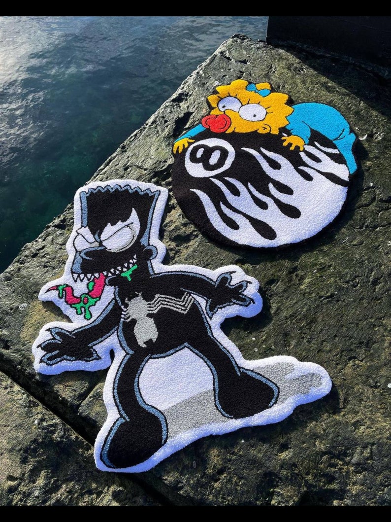 May include: Three colorful, handmade rugs featuring cartoon characters. One rug depicts Bart Simpson as Venom, another shows Maggie Simpson on an 8-ball, and the third is a Bart Simpson rug. The rugs are black, white, yellow, blue, and green.