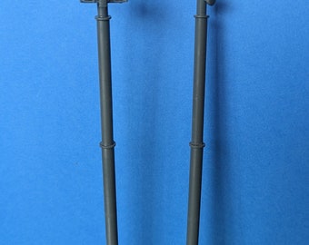 May include: Two gray metal cell phone towers with antennas and a gray metal box.