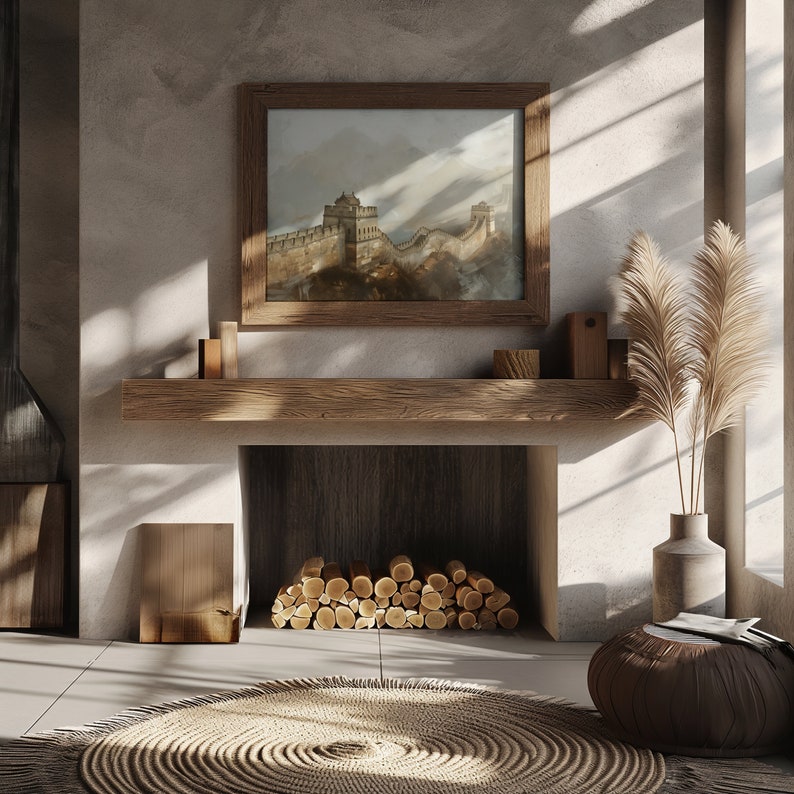 May include: A wooden mantelpiece with a fireplace below. The fireplace has a stack of logs inside. A framed picture of the Great Wall of China hangs above the mantelpiece. A vase with dried pampas grass sits on the floor next to a brown pouf.