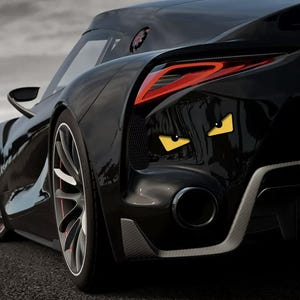 May include: A sleek black sports car featuring a glossy finish, aerodynamic body lines, and a prominent rear exhaust pipe. The vehicle is decorated with two yellow, triangular eye-shaped decals on the rear panel, adding a distinct graphic element.
