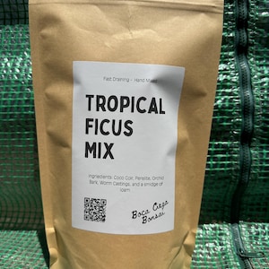 Może przedstawiać: Brązowa papierowa torba z białą etykietą z napisem "TROPICAL FICUS MIX". Etykieta zawiera składniki takie jak włókno kokosowe i kora storczyków. Torba jest zapieczętowana i zawiera kod QR oraz słowa "Boca Ciega Bonsai."