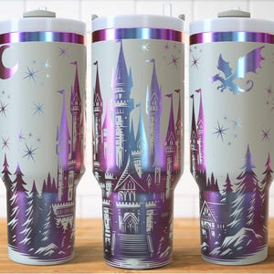 Puede incluir: Tres vasos aislados con asas, con un dise&ntilde;o de castillo de fantas&iacute;a en tonos morado, azul y plateado. Los vasos tienen una base blanca, un borde plateado y un asa gris. El dise&ntilde;o incluye estrellas, &aacute;rboles y un drag&oacute;n.