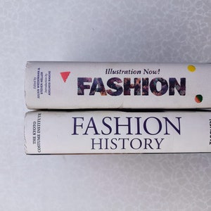 May include: Two hardback books stacked on top of each other. The top book is titled "Fashion Illustration Now!" and the bottom book is titled "Fashion History". Both books are published by Taschen.