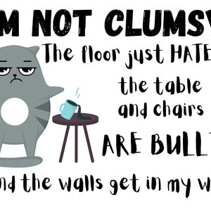 Peut inclure: Un chat gris de dessin animé avec une expression grincheuse est montré en train de renverser une tasse de café. Le texte dit "Je ne suis pas maladroit ! Le sol me déteste tout simplement, la table et les chaises sont des brutes et les murs me gênent."
