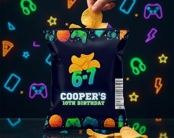 Può includere: Un sacchetto di patatine blu navy a tema gaming, con grafica verde e viola neon. Il sacchetto recita "COOPER'S 10TH BIRTHDAY" e "6-7". Una mano si allunga nel sacchetto per prendere una patatina. Lo sfondo presenta icone di gioco al neon.
