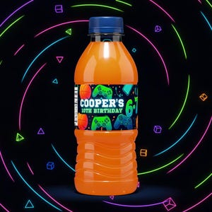 May include: An orange juice bottle with a blue cap and a custom label. The label reads "COOPER'S 10TH BIRTHDAY" with gaming-themed graphics, including basketballs and game controllers. The background features neon lines and shapes.