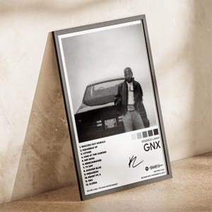 Puede incluir: P&oacute;ster enmarcado en blanco y negro con Kendrick Lamar y un coche. El p&oacute;ster incluye una lista de canciones, el t&iacute;tulo del &aacute;lbum "GNX" y una firma. La fecha de lanzamiento es el 22 de noviembre de 2024.