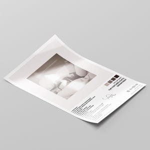 Puede incluir: Una impresi&oacute;n en papel blanco con una imagen en escala de grises y texto. El texto incluye "THE TORTURED POETS DEPARTMENT" y una lista de t&iacute;tulos de canciones. Hay una firma presente. La impresi&oacute;n est&aacute; en &aacute;ngulo sobre una superficie gris.