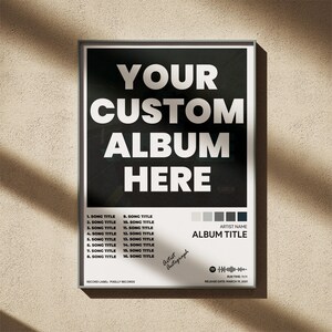 Puede incluir: Un p&oacute;ster enmarcado con un dise&ntilde;o en blanco y negro. El p&oacute;ster presenta el texto "YOUR CUSTOM ALBUM HERE" en letras blancas grandes. Debajo, hay espacios para los t&iacute;tulos de las canciones, el nombre del artista y el t&iacute;tulo del &aacute;lbum. Incluye un c&oacute;digo QR y el texto "Artist Autograph."