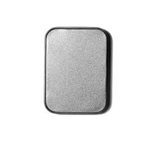 May include: A silver metal makeup compact with a black rim.