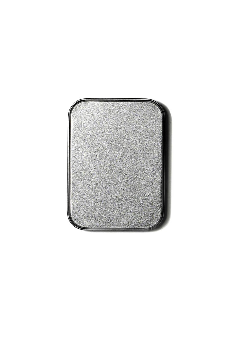 May include: A silver metal makeup compact with a black rim.