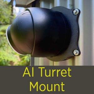 May include: A black AI turret mount is attached to a metal surface with four bolts. The mount has a rounded, dome-like shape with a lens. The text "AI Turret Mount" is displayed in yellow.