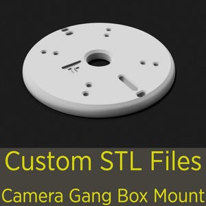 May include: A white, circular camera gang box mount with multiple holes and a central opening. The mount has a flat surface and rounded edges. Text at the bottom reads "Custom STL Files" and "Camera Gang Box Mount".