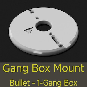 May include: A white, circular Gang Box Mount for a Bullet 1-Gang Box. The mount has a central hole and several smaller holes and slots for mounting hardware. The text "Gang Box Mount" and "Bullet - 1-Gang Box" are displayed in yellow.