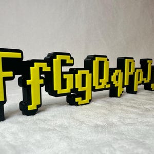May include: Black and yellow pixelated letters spelling out "FfgQqPpj" on a white background.