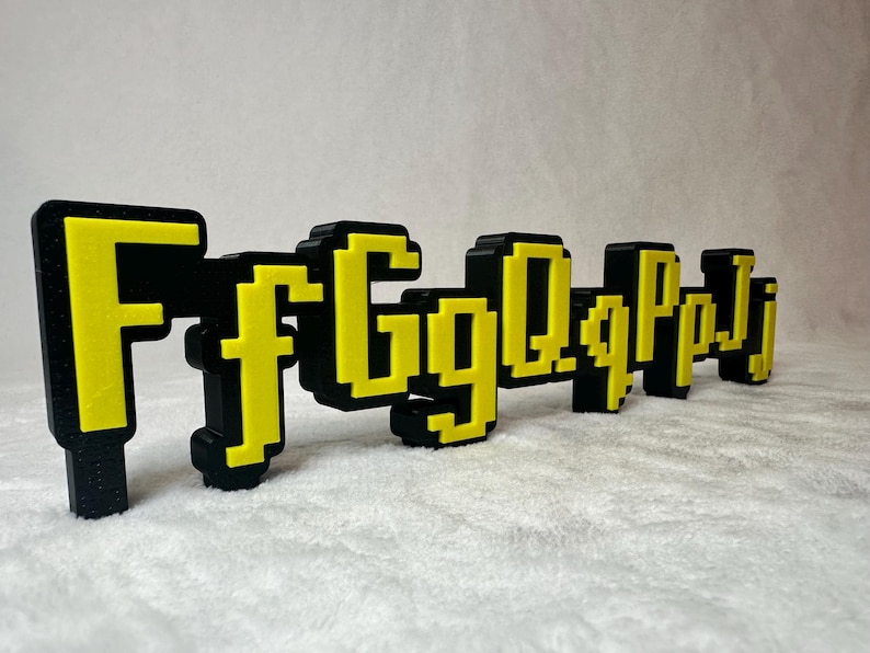 May include: Black and yellow pixelated letters spelling out "FfgQqPpj" on a white background.