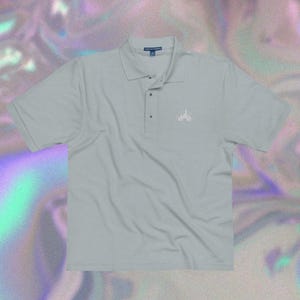 May include: A light gray polo shirt with a white embroidered design of a castle on the left chest.