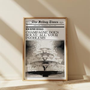 May include: A framed print of a newspaper page titled "The Friday Times." The headline reads "Champagne Does Solve All Your Problems." Below, a tiered display of champagne glasses is visible, with a sparkling effect.
