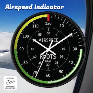 May include: Black and white clock with a round face and a green and yellow ring around the edge. The clock face has the words "Airspeed Indicator" and "Knots" printed on it. The clock hands are white and point to the numbers 120 and 30.