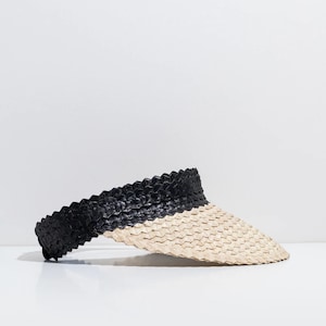 May include: A black and beige woven visor hat. The visor is curved and the hat is made of a woven material.