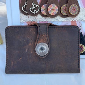 Cartera de piel auténtica de búfalo de agua con un bonito cierre de presión plateado.