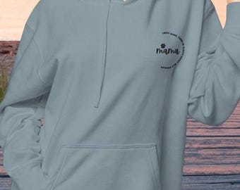 Op de afbeelding: Een lichtblauw hoodie met een zwarte pootprint en de tekst "Treat giver, Zoner of Biscuits, Stay Cuddly, Mama" in een cirkel rond de pootprint.