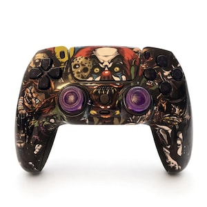 Peut inclure: Une manette de jeu vidéo sans fil avec un revêtement graphique sombre et multicolore représentant divers personnages de films d'horreur, dont un clown et un masque de hockey. Elle possède des boutons noirs et deux joysticks violets translucides.