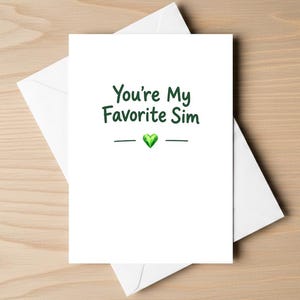 May include: A white greeting card with a white envelope featuring the dark green text "You're My Favorite Sim" centered above a small, green, faceted diamond-shaped icon flanked by two horizontal lines, all printed on a clean white background.