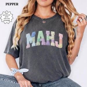 May include: A set of three ceramic mugs with a speckled, matte finish. The mugs are in shades of cream, light gray, and dark gray. Each mug has a simple, minimalist design and a rounded handle.