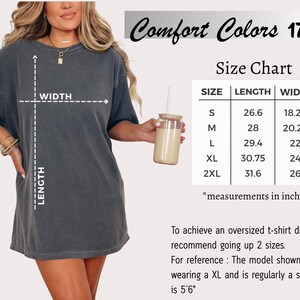 May include: A woman wearing a dark gray oversized t-shirt dress. The image includes a size chart with measurements in inches. The text "Comfort Colors 1717" is at the top. The model is wearing an XL and is 5'6".