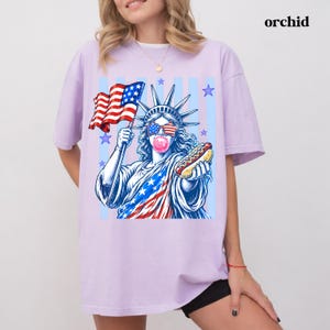 USA 250th anniversary tee with Statue of Liberty holding a hot dog and American flag.