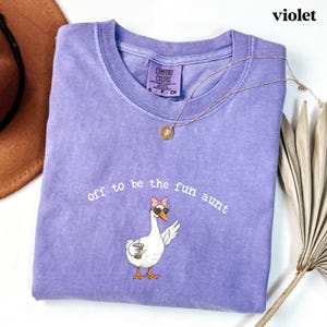 Cute goose design with bow sunglasses and drink printed on trendy aunt themed t shirt.