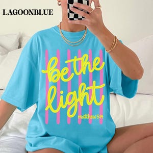 Be the Light Christian Comfort Colors shirt with Bible verse design.
